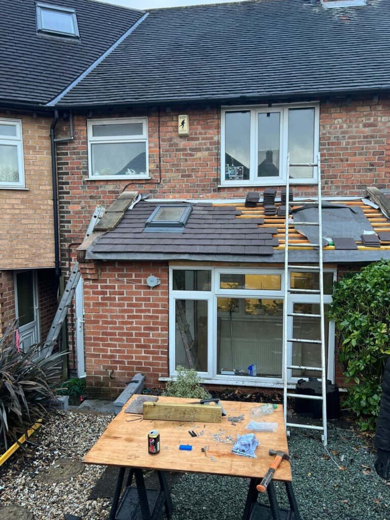 This is a photo of a roof extension that is having new roof tiles installed. This is a photo taken from the roof ridge looking down a tiled pitched roof on to a flat roof. Works carried out by MCM Roofing Repairs Devizes